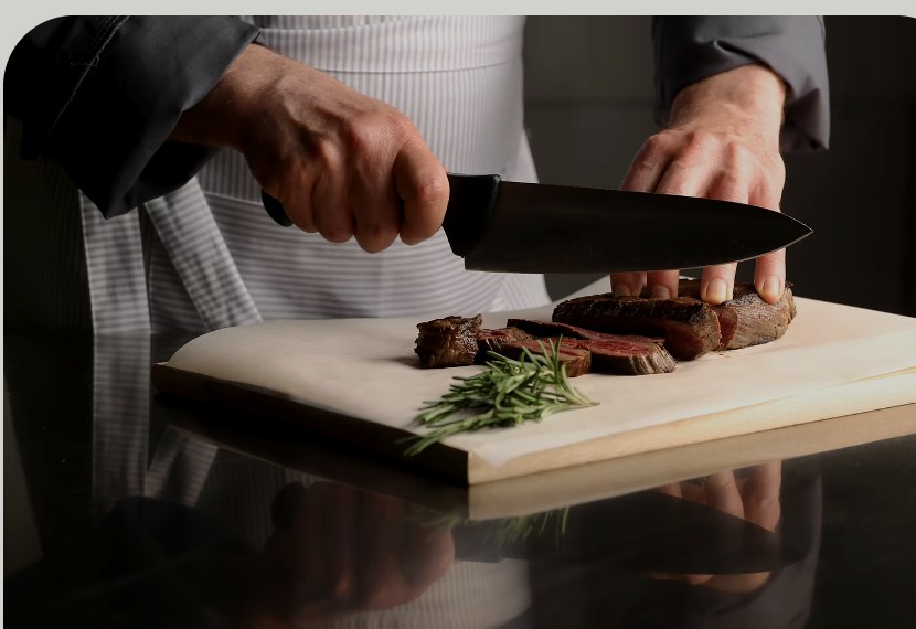 Chef cortando carne en una tabla